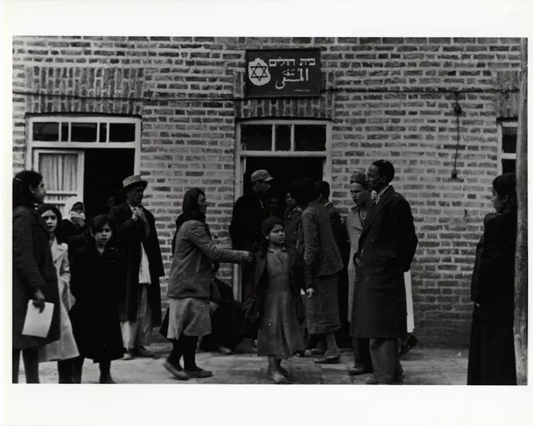 An archival photograph of people in front of a building.