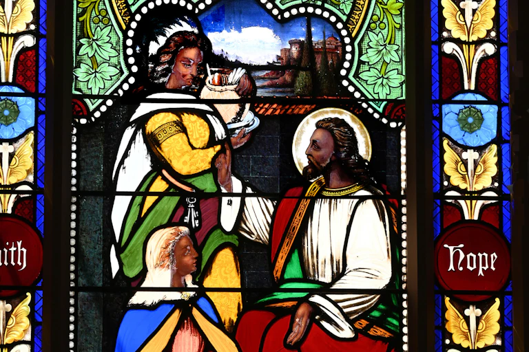 A colorful painting showing a bearded man with dark hair and skin, with two women who are looking at him.