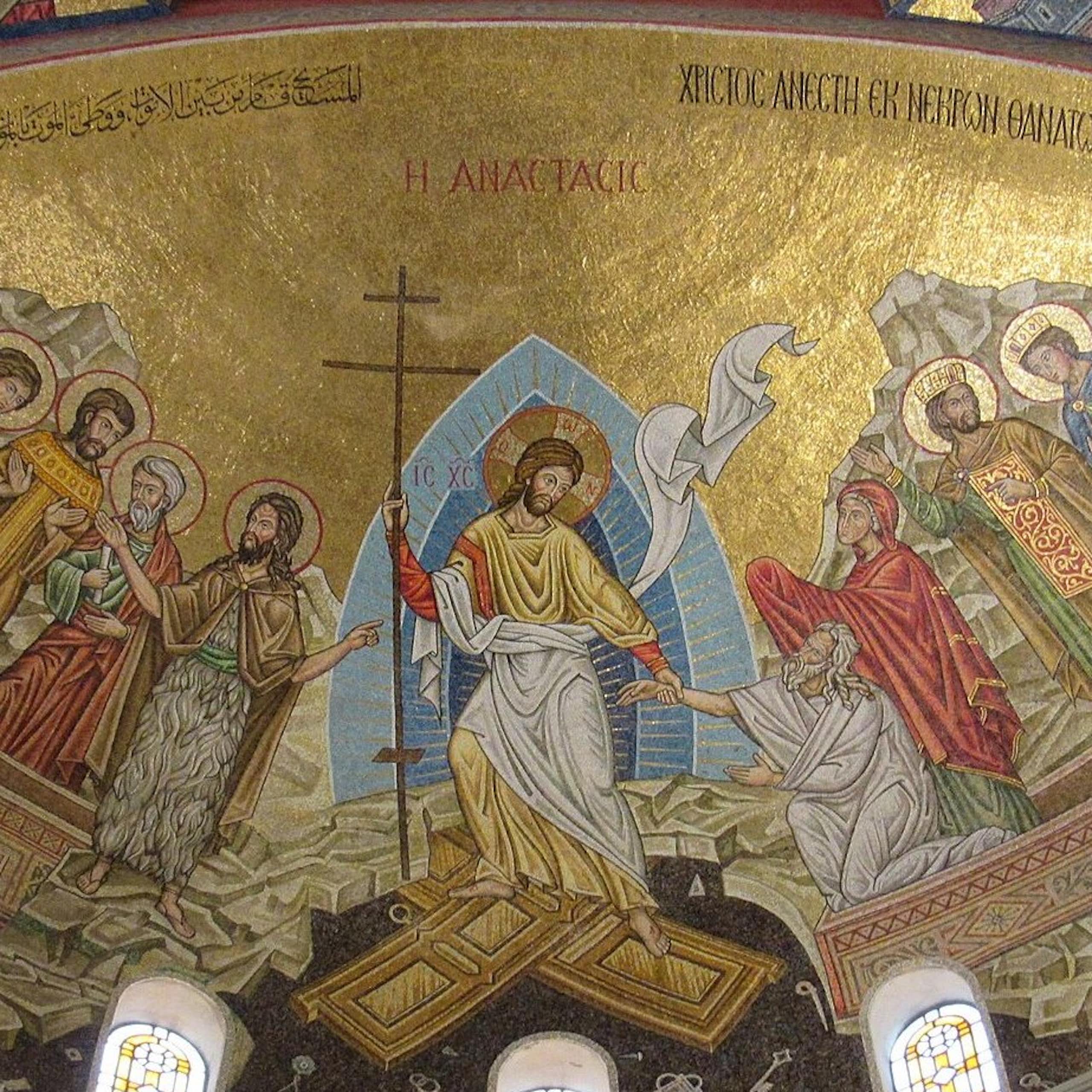 A mosaic with a golden background, six figures with halos, Jesus holding a cross in the middle, and two people whom he is helping out of coffins.