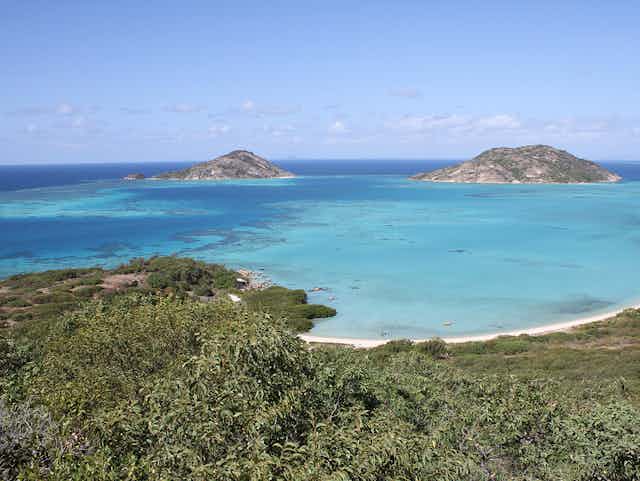 A photo of a shallow lagoon of blue water, fringed by green islands.