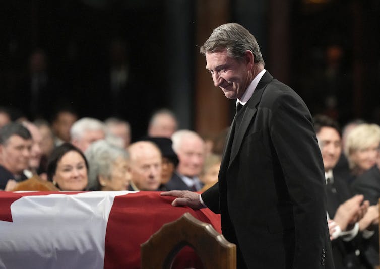 Gretzky places his hand on the flag-covered casket