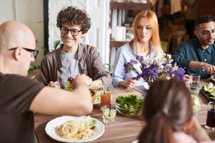 A group of people eating around a table.