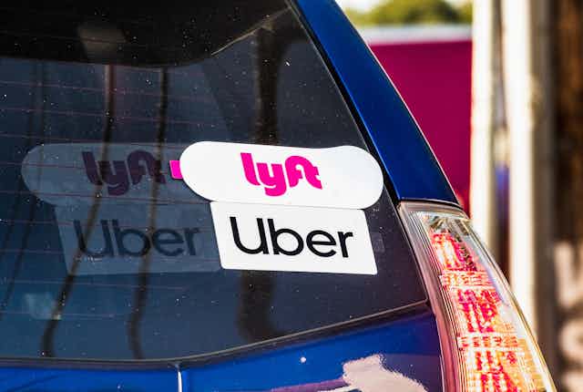 the back window of a car showing Uber and Lyft stickers
