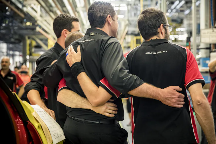workers embrace in factory