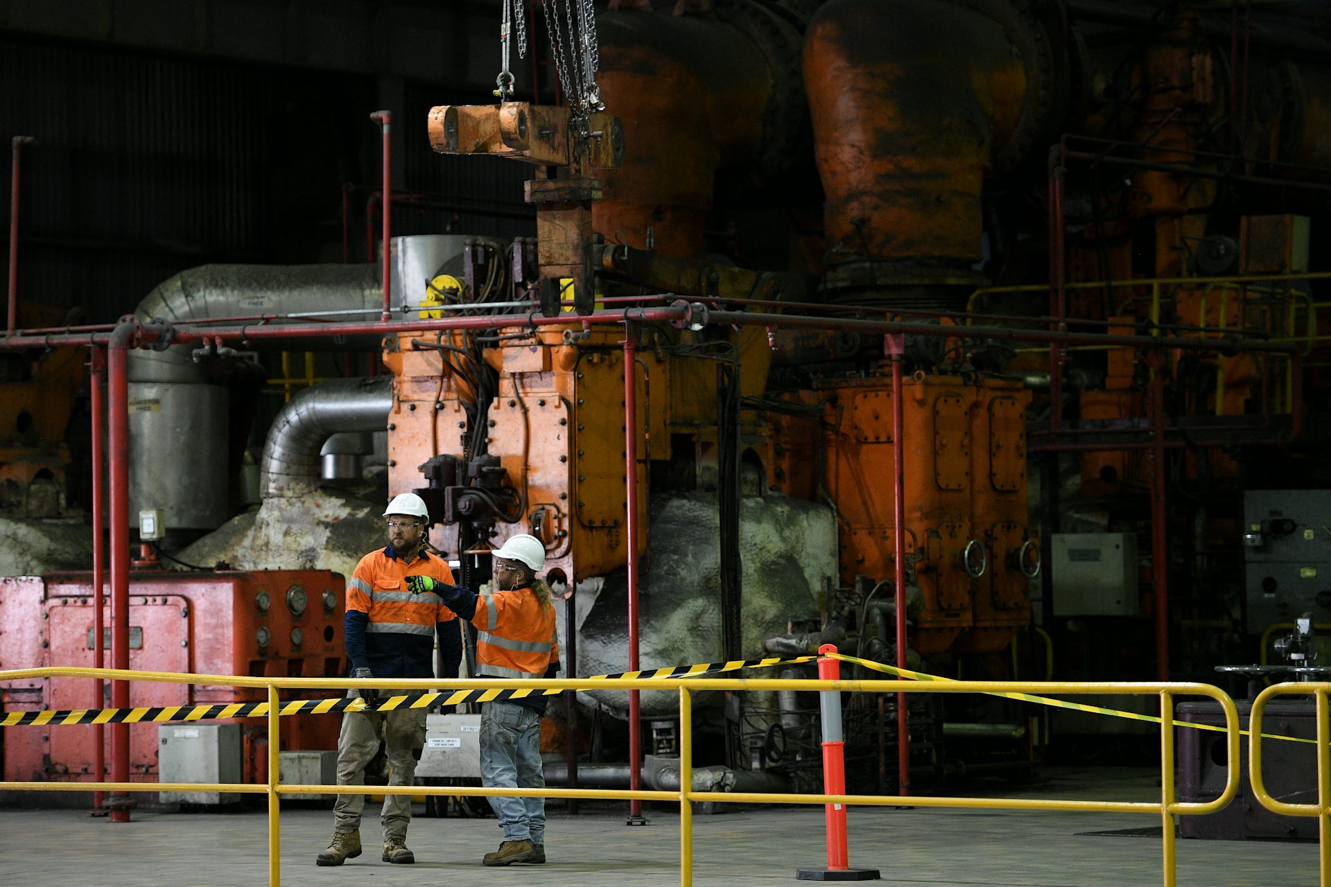 two coal plant workers in front of machinery