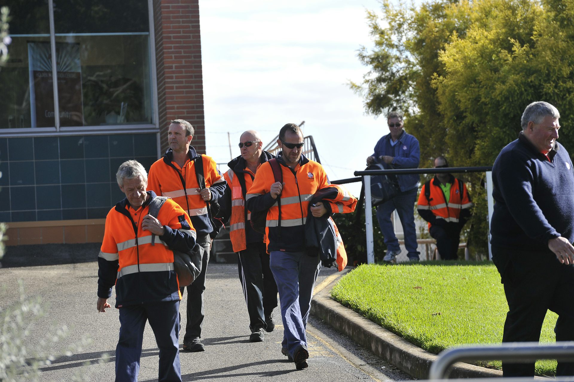 men leaving work in high-vis gear