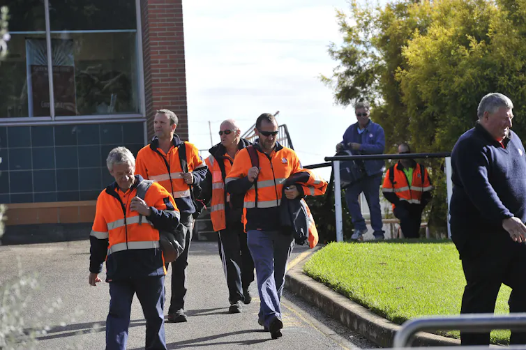 men leaving work in high-vis gear