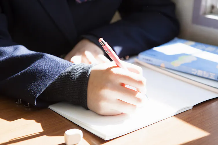 A student writes in a notebook.