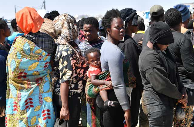 African migrants attempting to flee to Europe disembark in Sfax from a vessel belonging to the Tunisian coastguard, after having been intercepted at sea, on 10 August 2023.