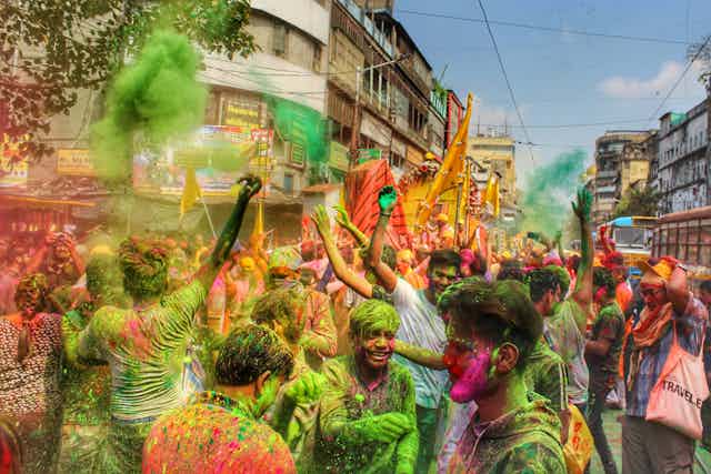 A crowd with clouds of coloured powders.