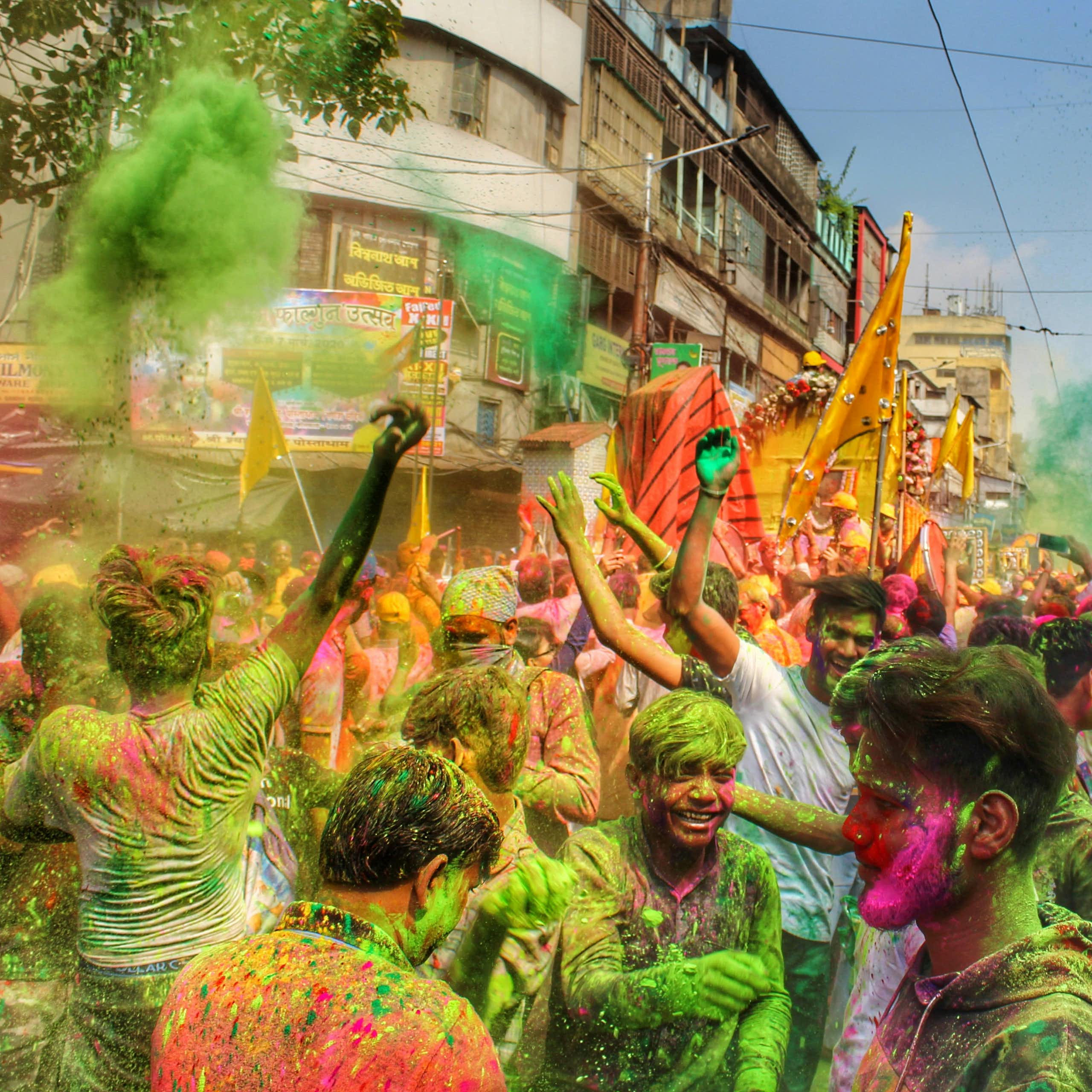 A crowd with clouds of coloured powders.