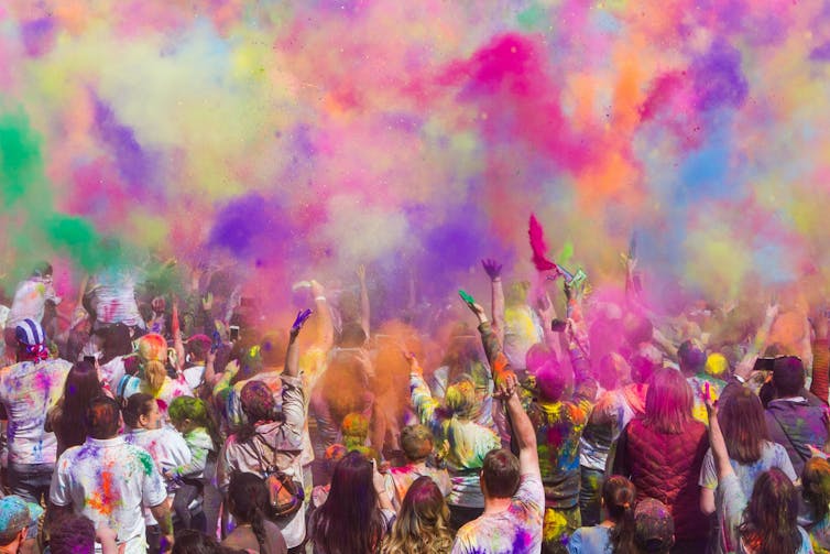 A crowd under a sky of colours.
