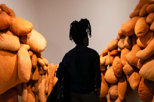 Silhouette of a woman looking at a textile installation