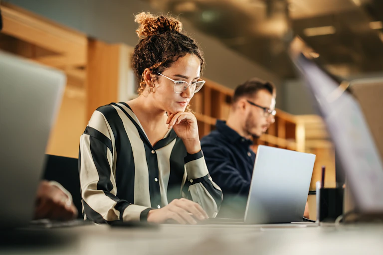 Serious young woman at laptop