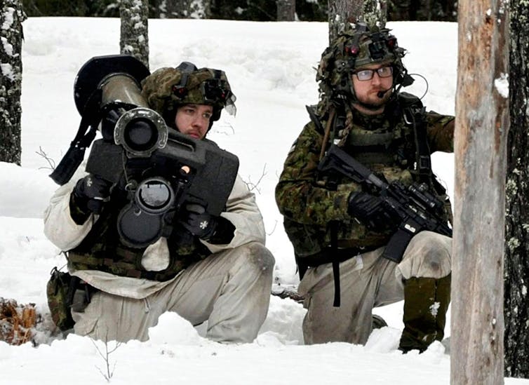 Two soldiers on a winter Nato exercise in the snow.