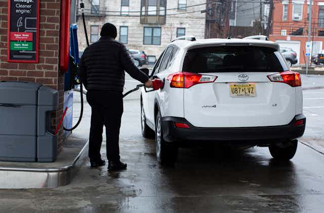 A gas station attendant refuels a car at a gas station in Weehawken, New Jersey, in March 2022.