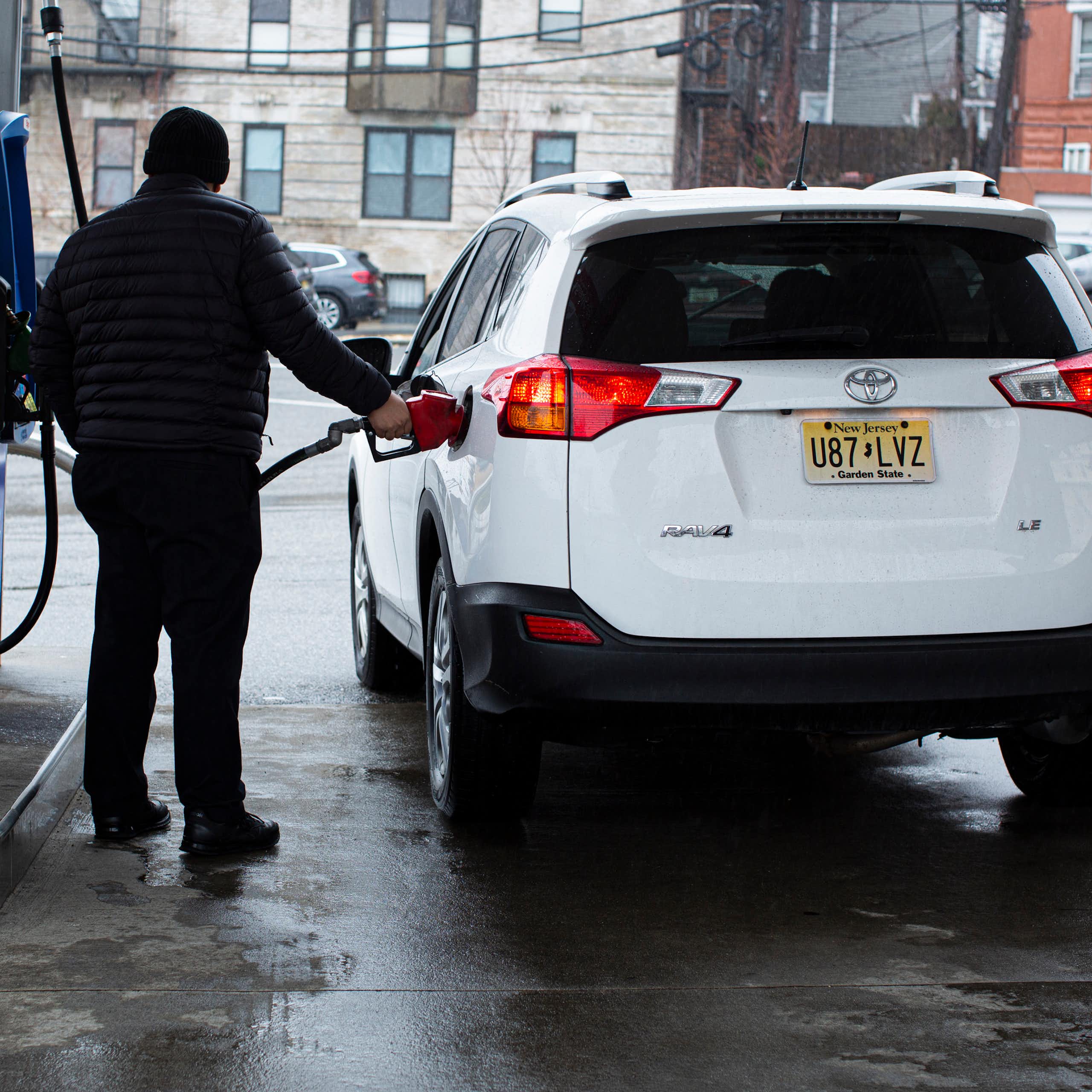 A gas station attendant refuels a car at a gas station in Weehawken, New Jersey, in March 2022.