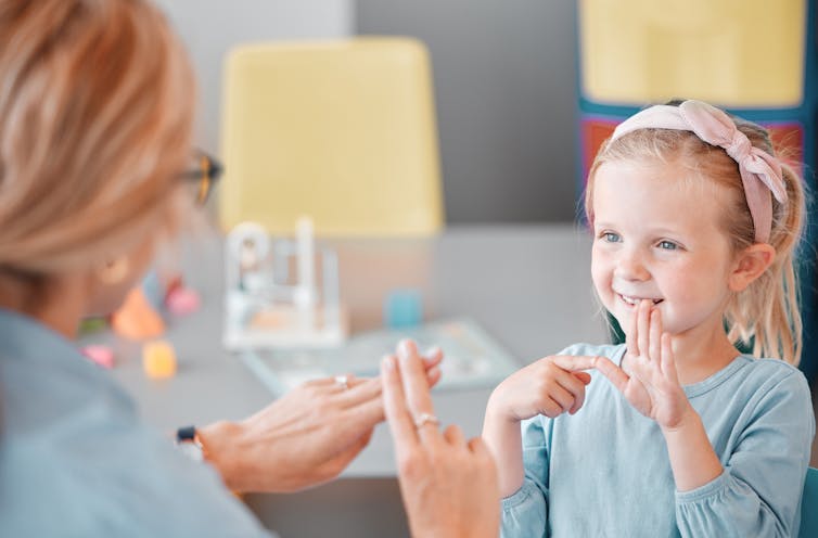 A girl in a doctor's room using sign language