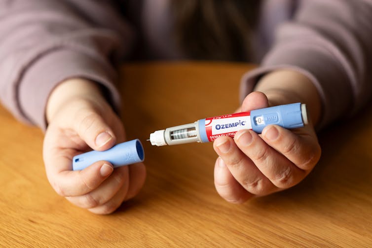 Person holds Ozempic injection