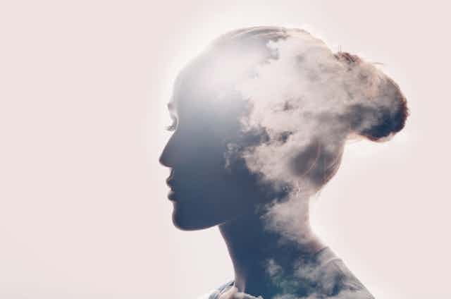 Collage of a photo of a silhouette of a woman's head with clouds.