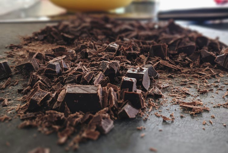 Chopped up dark chocolate on a board.