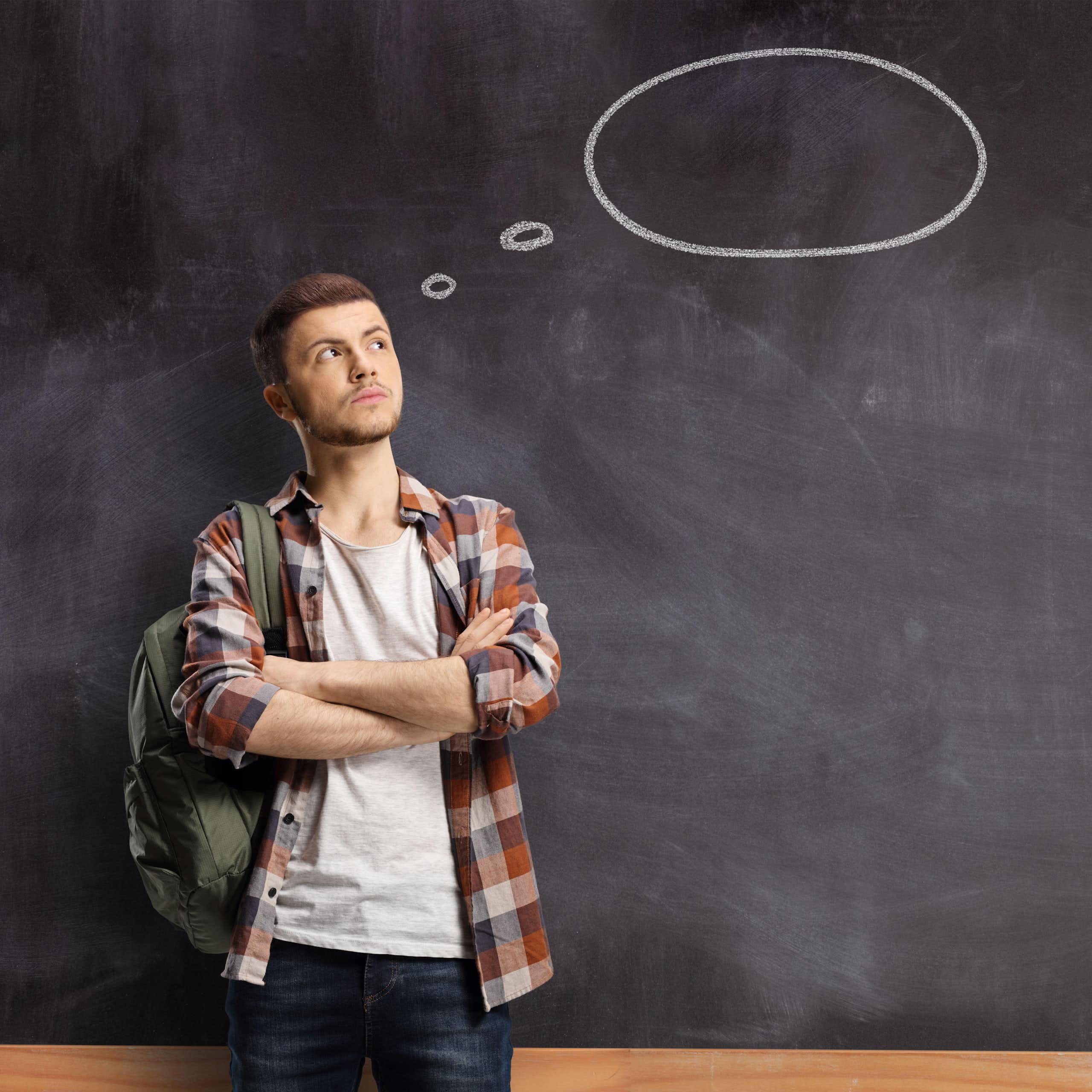Young man with a blank thought bubble behind him on a chalkboard