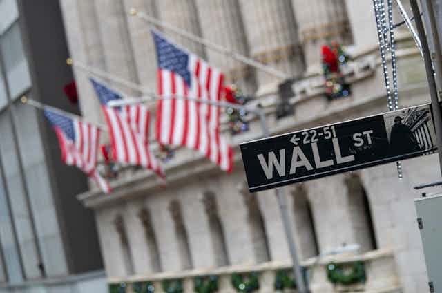The Wall Street sign is framed by American flags flying outside the New York Stock Exchange in New York City on Jan. 3, 2020.