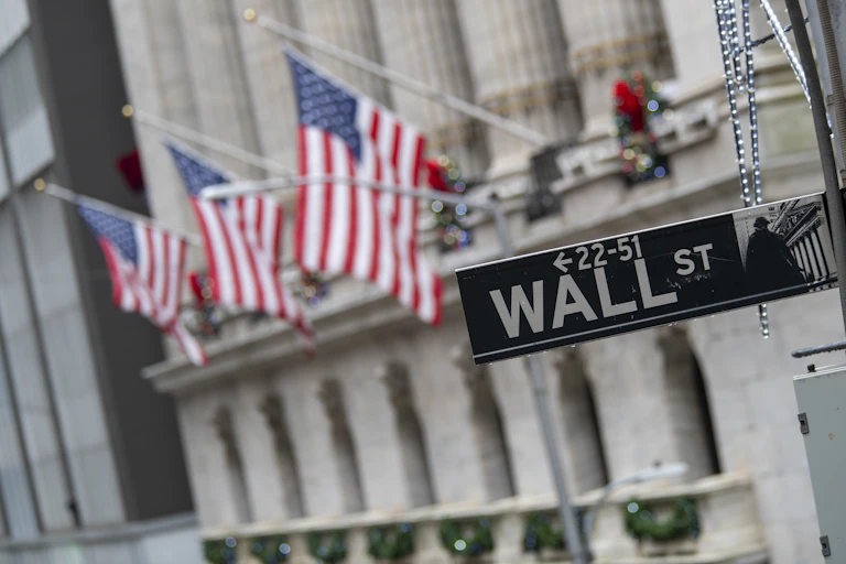 The Wall Street sign is framed by American flags flying outside the New York Stock Exchange in New York City on Jan. 3, 2020.