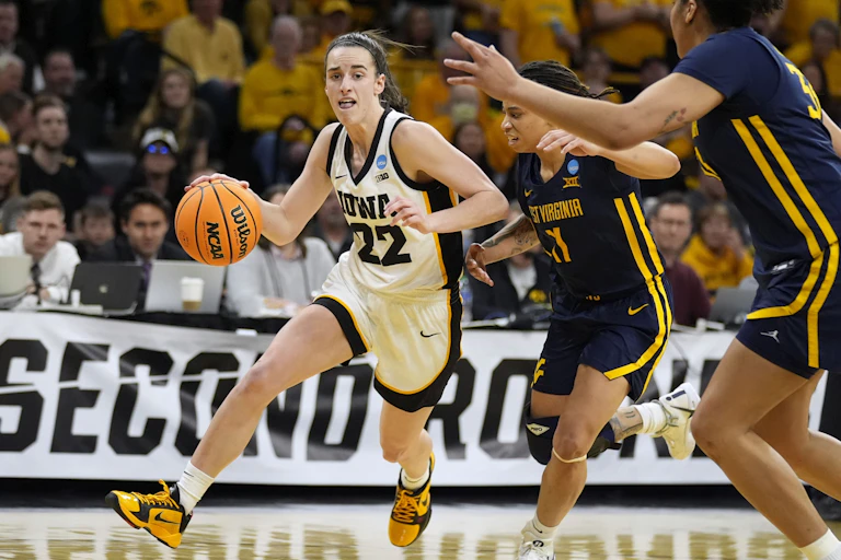 A woman basketball player dribbles the ball past two other women players from an opposing team