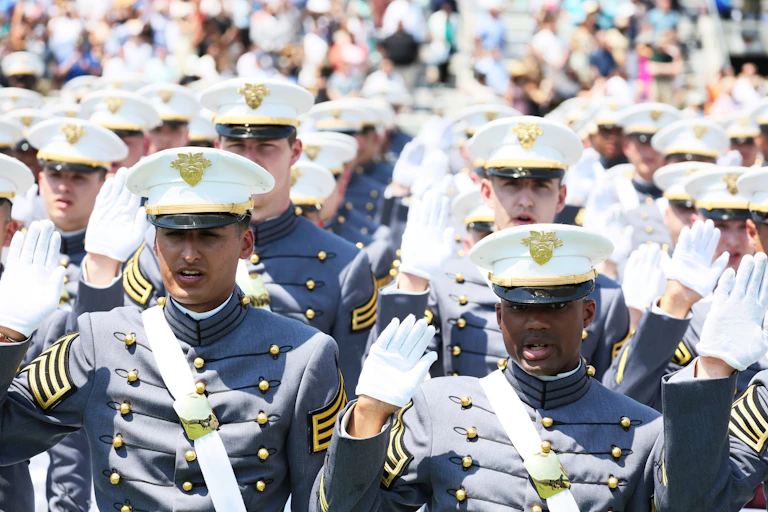 People in military uniforms raise their right hands.