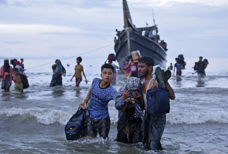 Rohingya refugees disembark from a boat in Indonesia.