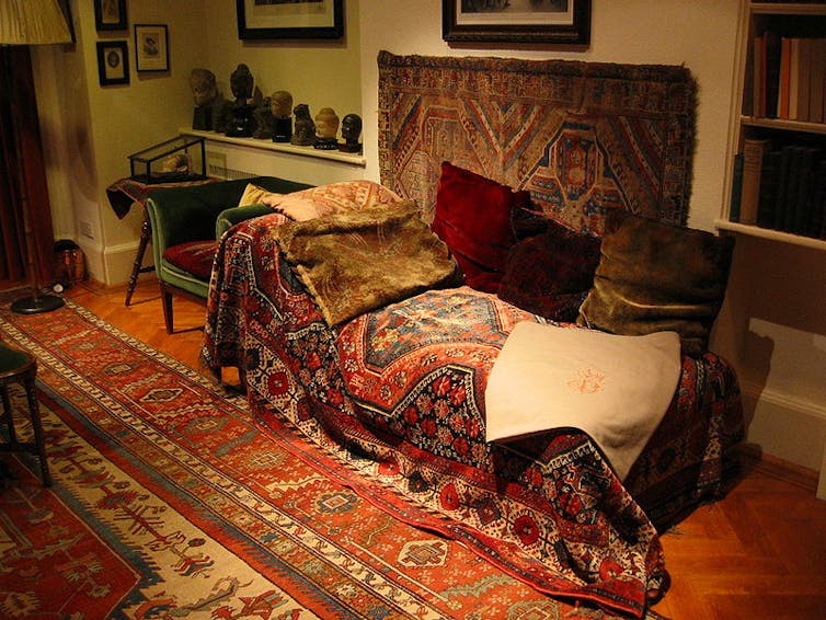 A couch covered with rugs on which Sigmund Freud's patients once lay during therapy sessions.