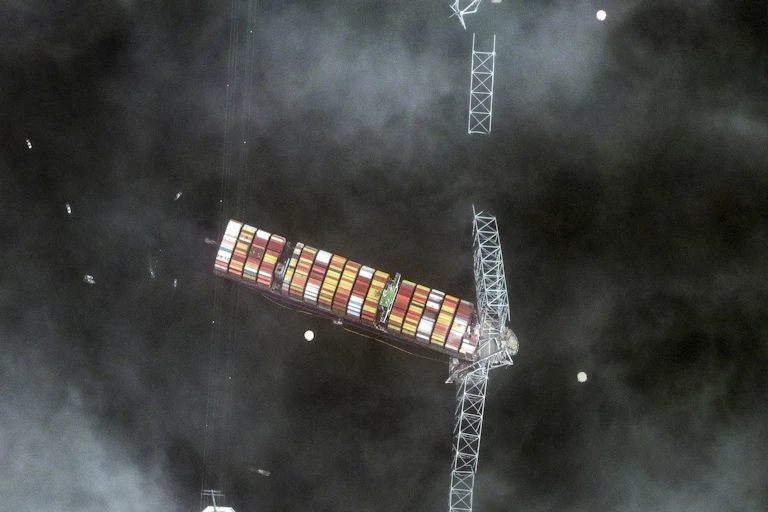 Satellite photo showing a container ship entangled with the wreckage of a bridge.