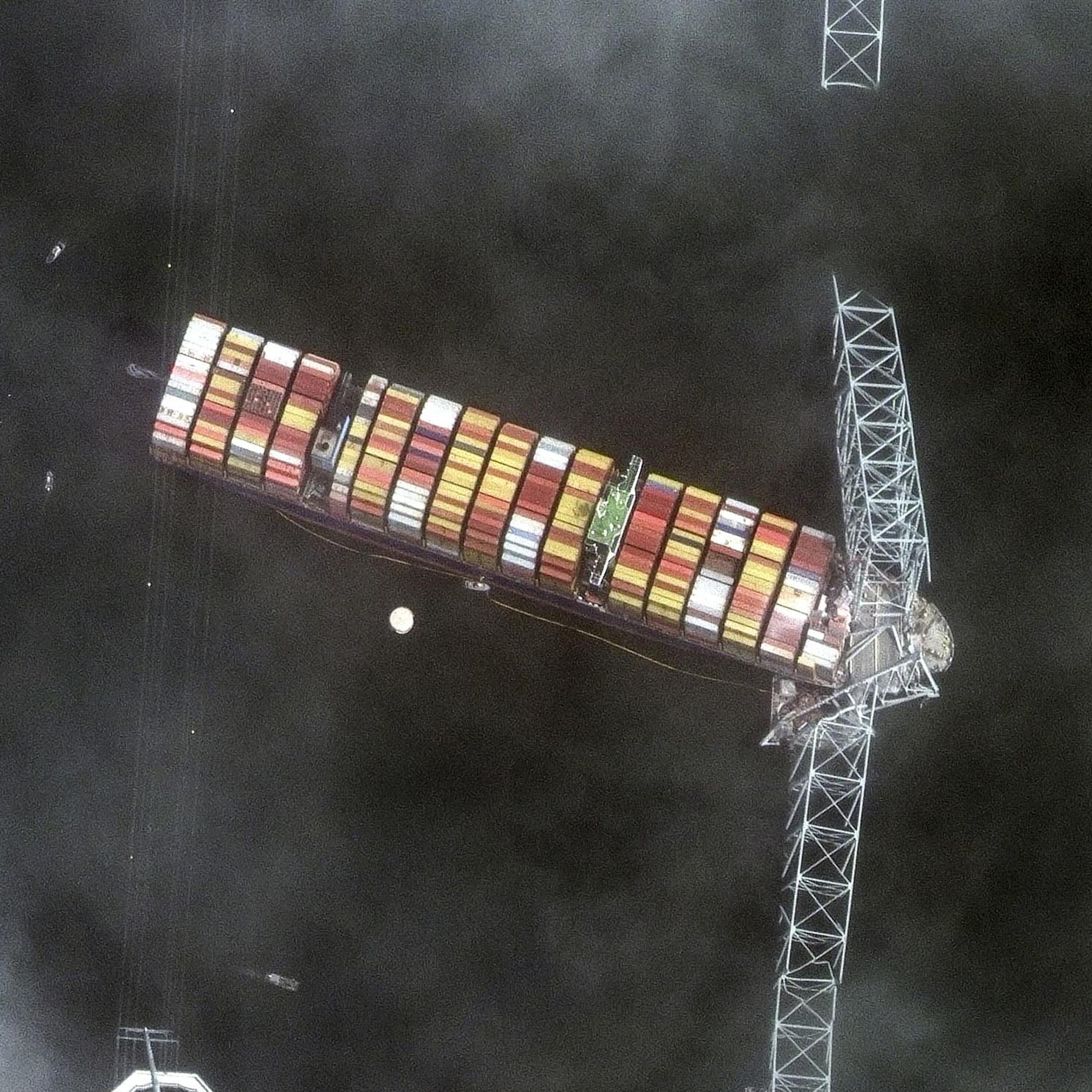 Satellite photo showing a container ship entangled with the wreckage of a bridge.