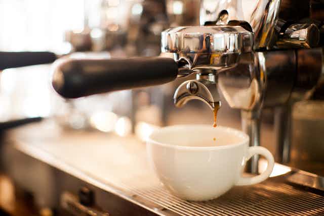 espresso pours out of coffee machine