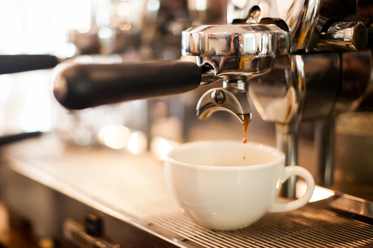espresso pours out of coffee machine