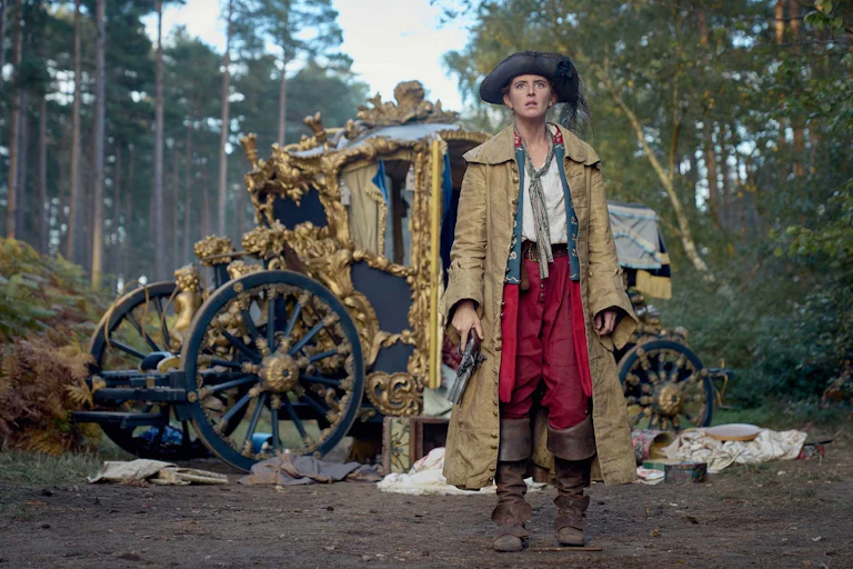 Renegade Nell holding a gun by a stagecoach