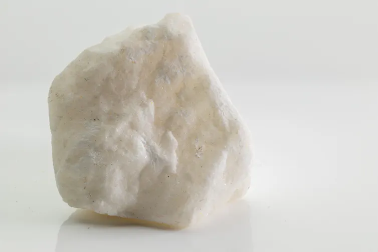A mineral is seen against a white background.