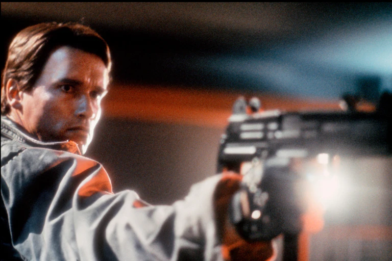 Arnold Schwarzenegger in The Terminator holding a gun