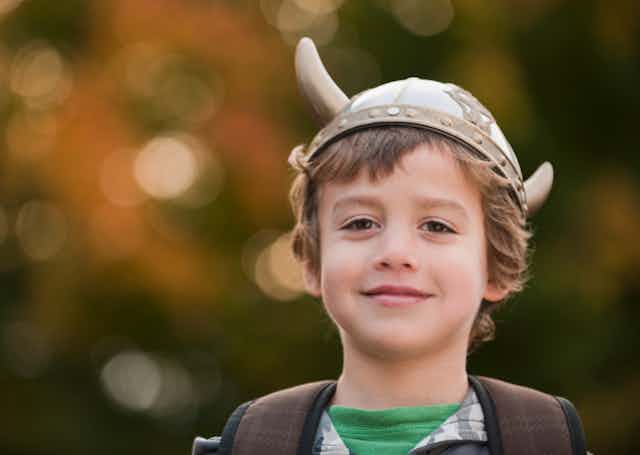 smiling boy wearing Viking hat with horns