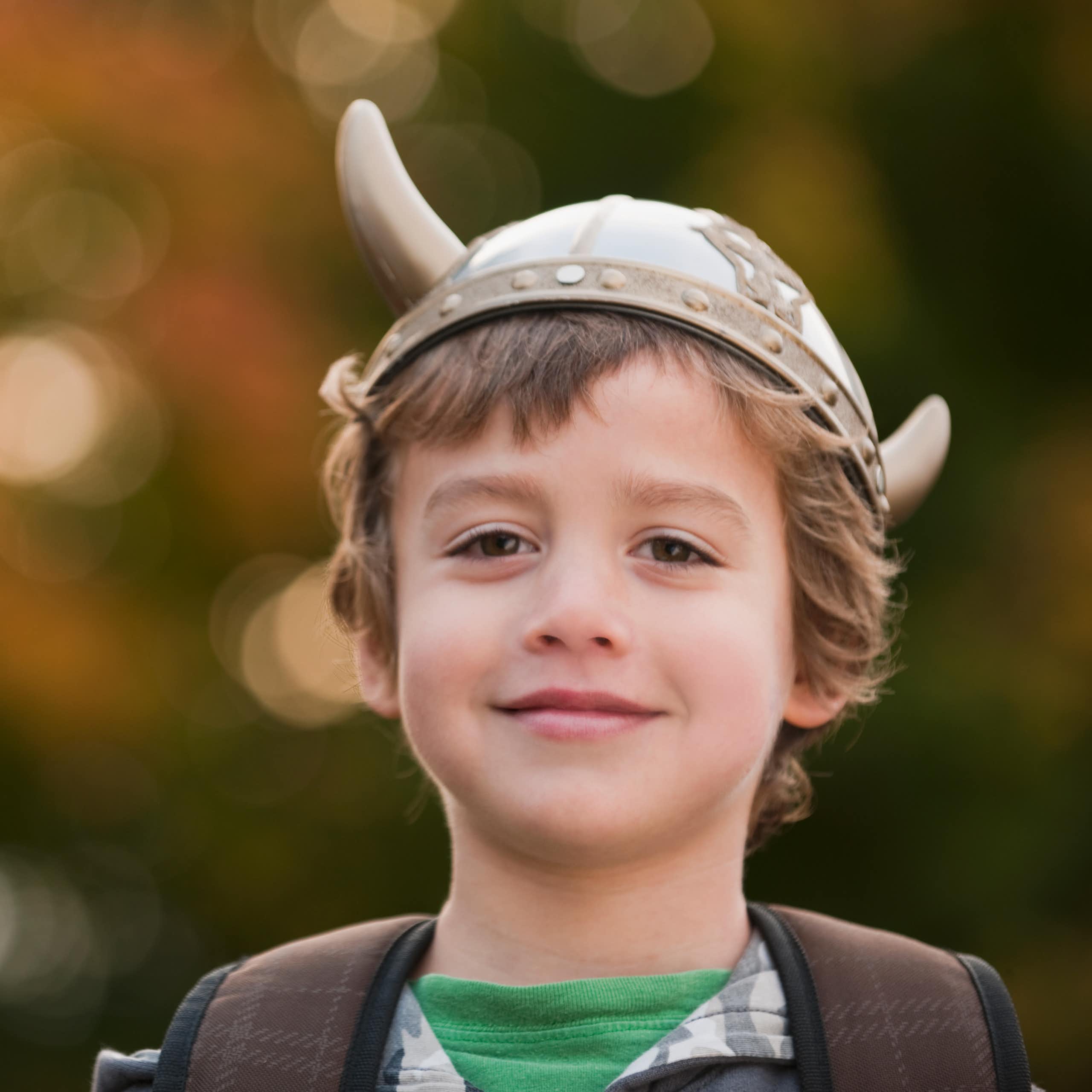 smiling boy wearing Viking hat with horns