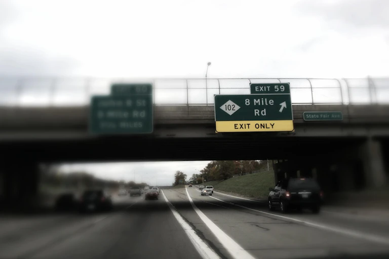 Road showing sign for 8 Mile Rd in Detroit.