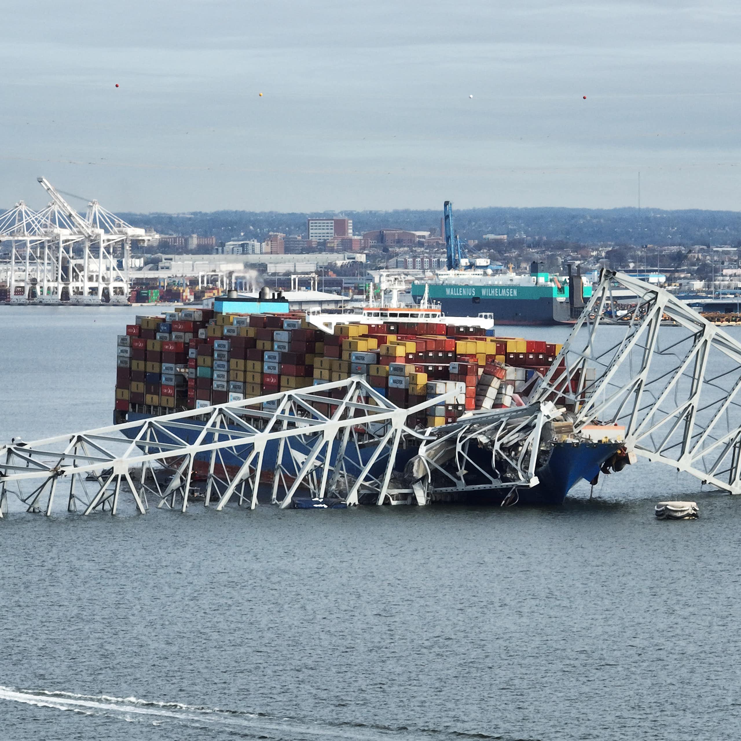 A cargo ship is ensnared in a mangled steel bridge.