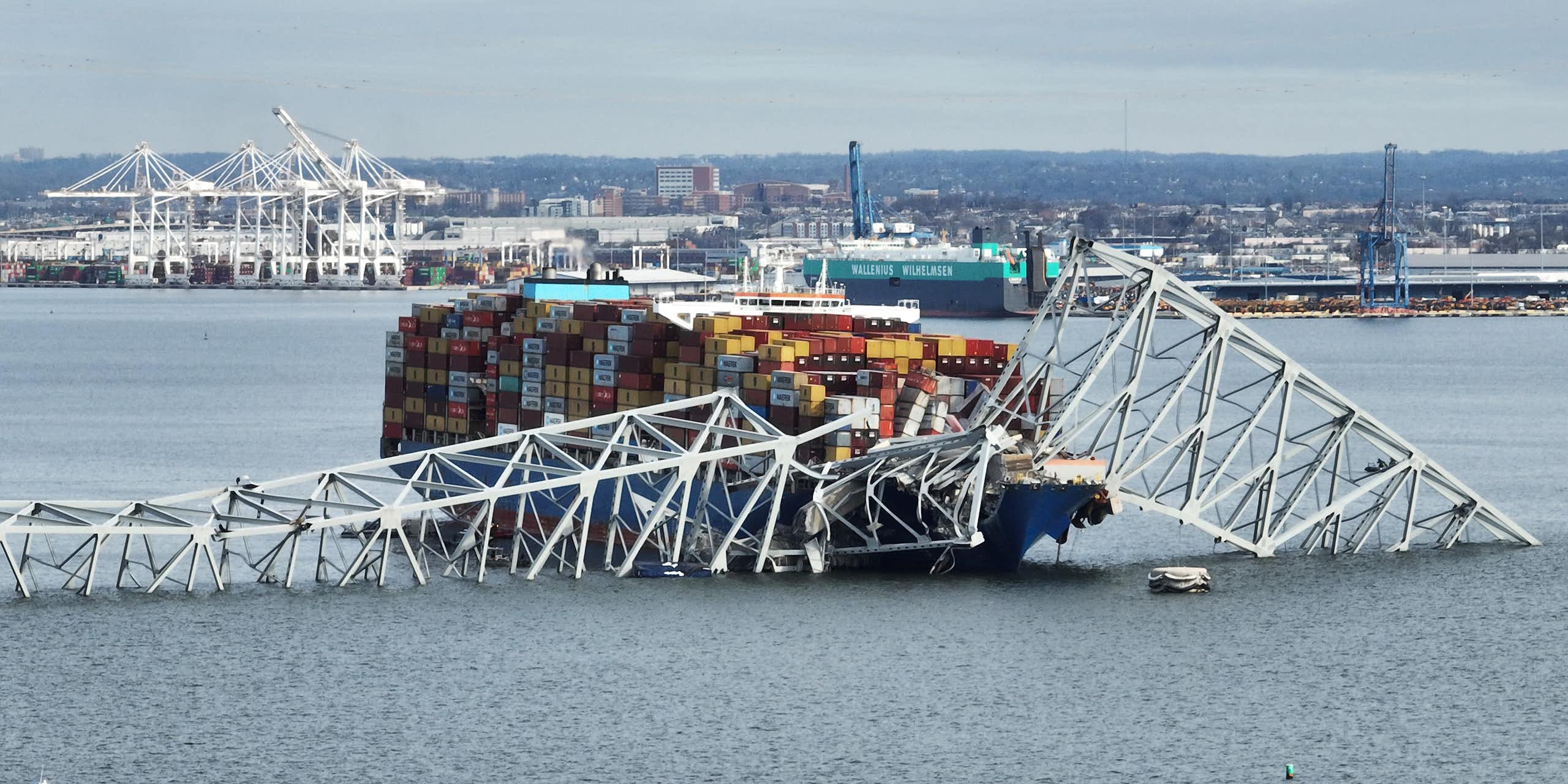 A cargo ship is ensnared in a mangled steel bridge.