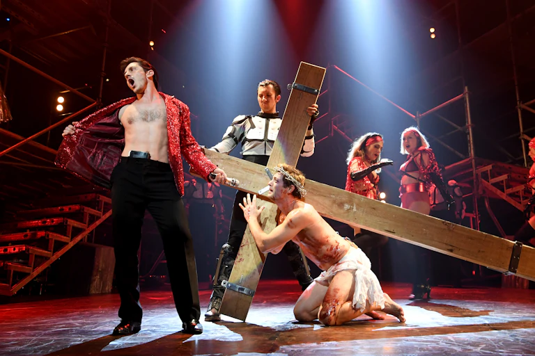 A musical theatre stage has a scene from Jesus Christ Superstar playing out on it