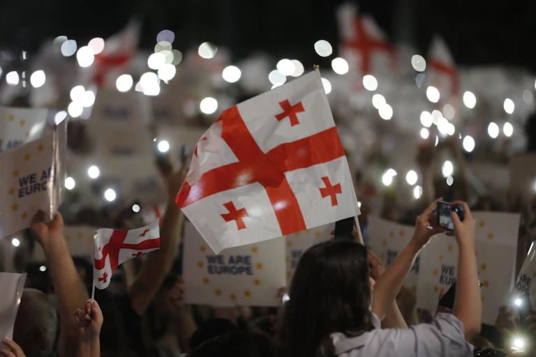 A crowd of people holding the Georgian national flag and placards reading: 'We are Europe".