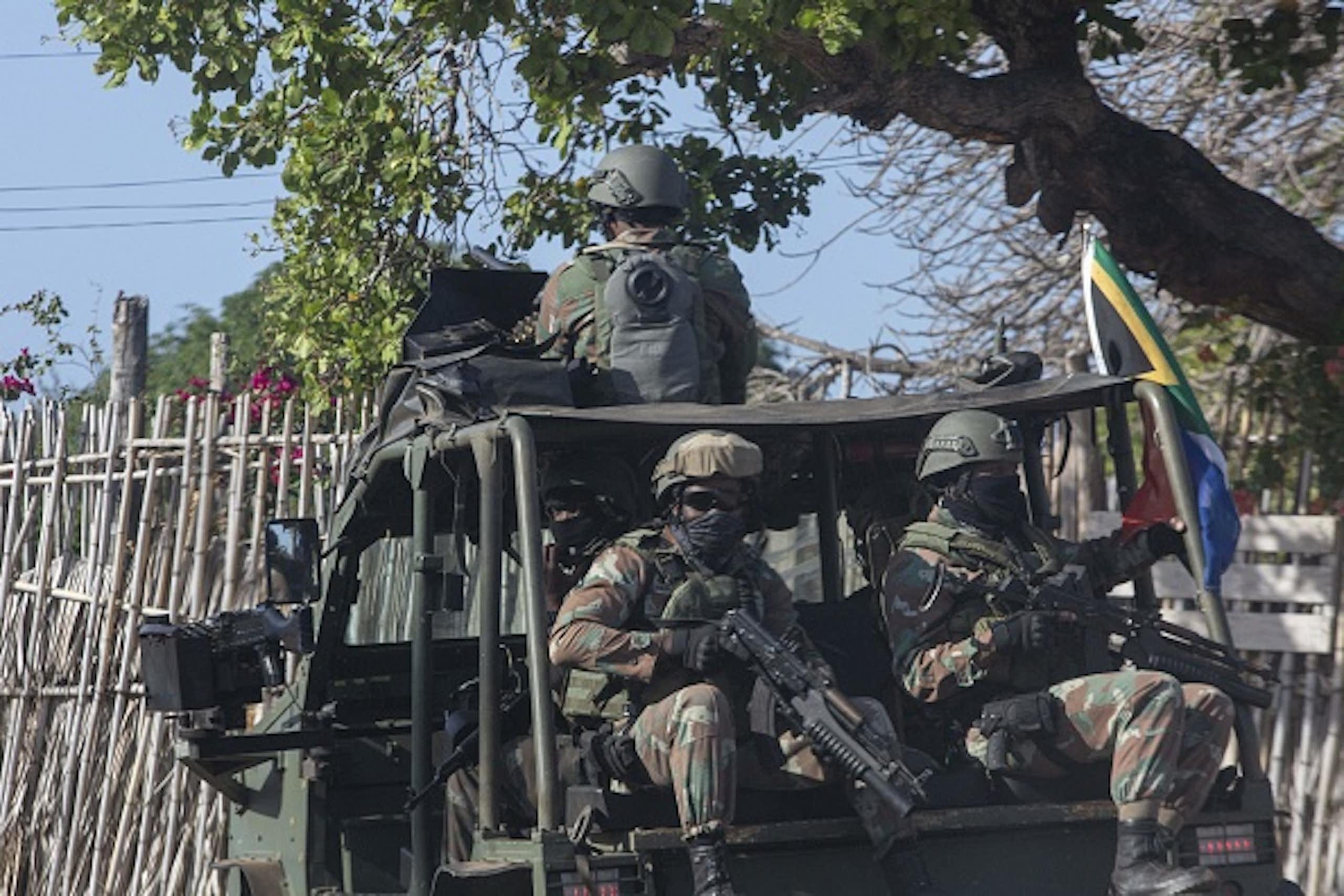 Soldiers in a military van waving the South African flag.