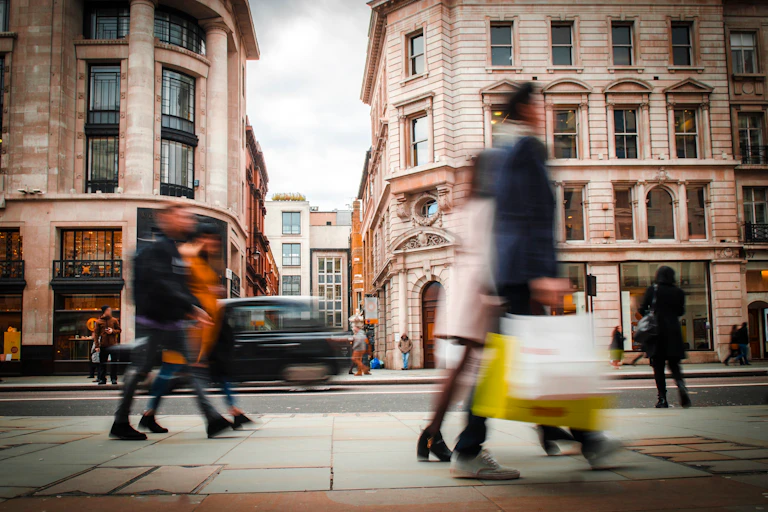 Blurred pedestrians on city street.