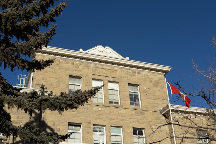 A school building seen with a flag flapping in wind.