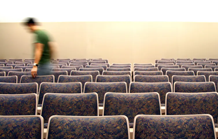 A student in a blur exiting a row of chairs.